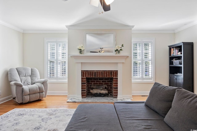 living room with plenty of natural light, a brick fireplace, ceiling fan, and light hardwood / wood-style floors