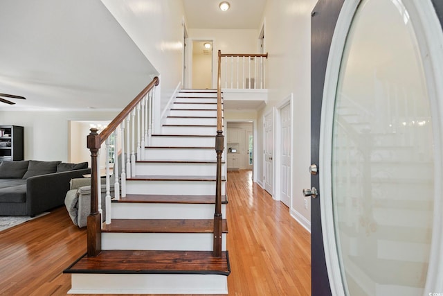 stairs featuring wood-type flooring and ceiling fan