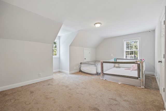 additional living space featuring a wealth of natural light, light carpet, and lofted ceiling