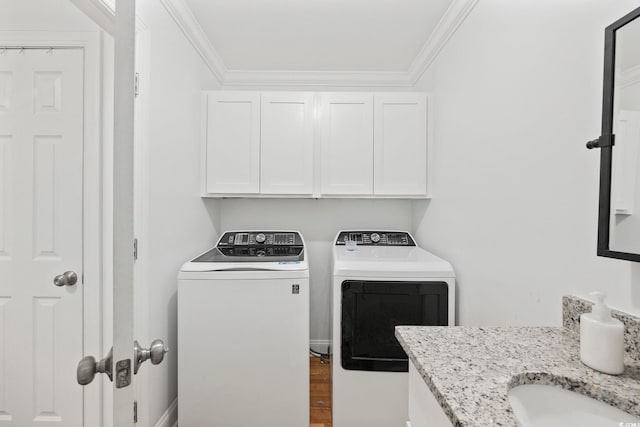 washroom with separate washer and dryer, ornamental molding, cabinets, and hardwood / wood-style floors