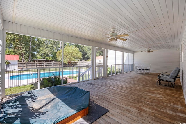 wooden deck featuring ceiling fan and a fenced in pool