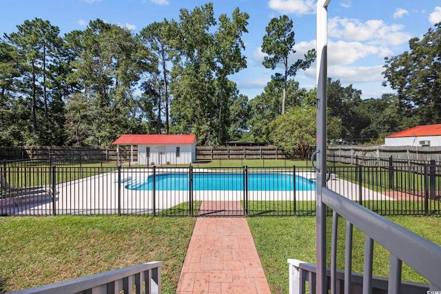 view of pool featuring a yard and a storage unit