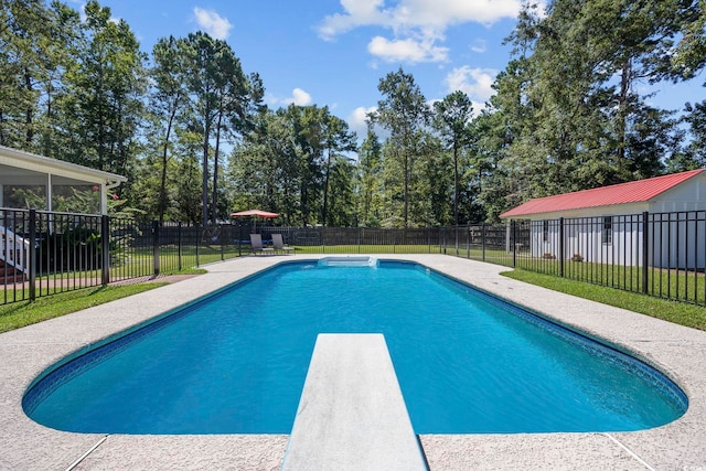 view of swimming pool with a yard and a diving board