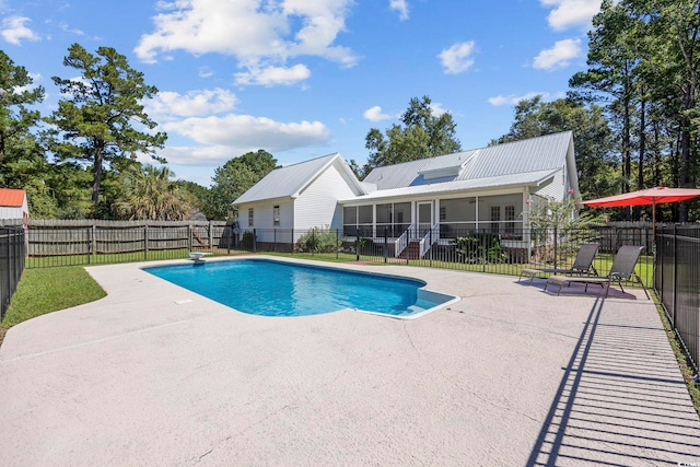 view of swimming pool with a diving board and a patio