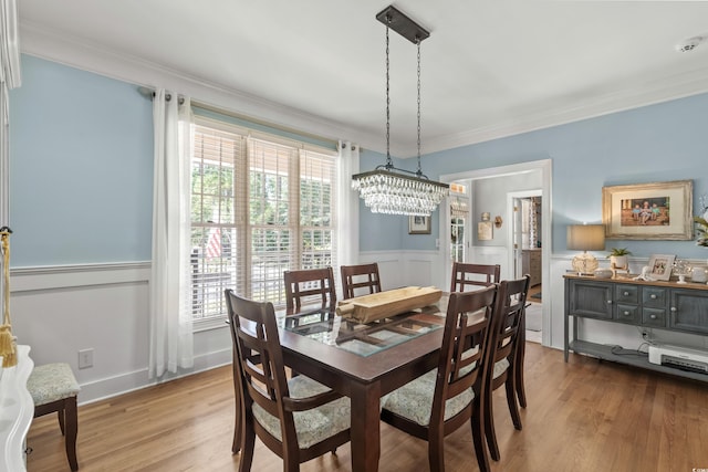 dining area featuring hardwood / wood-style floors, an inviting chandelier, and crown molding