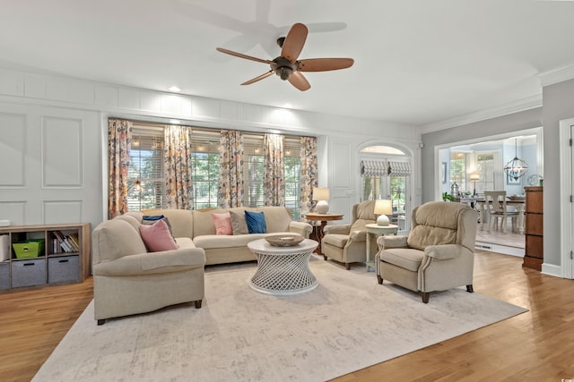 living room featuring hardwood / wood-style flooring, ceiling fan, and crown molding