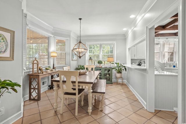 tiled dining room with crown molding and an inviting chandelier