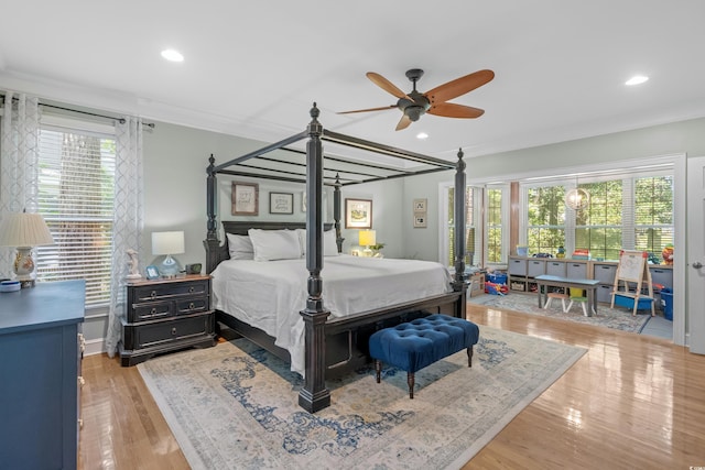 bedroom featuring ceiling fan, wood-type flooring, ornamental molding, and multiple windows