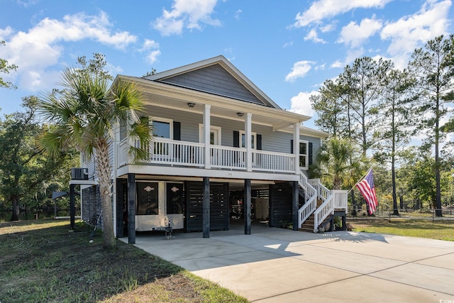 raised beach house with a carport, covered porch, and central air condition unit