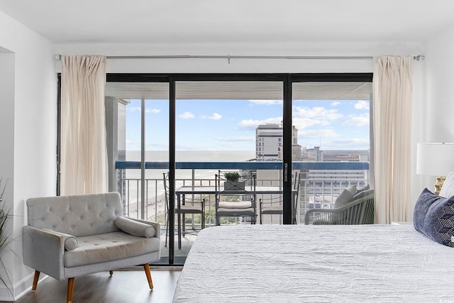 bedroom featuring a water view, hardwood / wood-style floors, and multiple windows