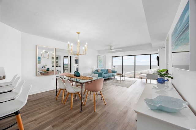 dining space featuring ceiling fan with notable chandelier and hardwood / wood-style floors