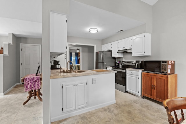 kitchen featuring white cabinets, appliances with stainless steel finishes, kitchen peninsula, and sink