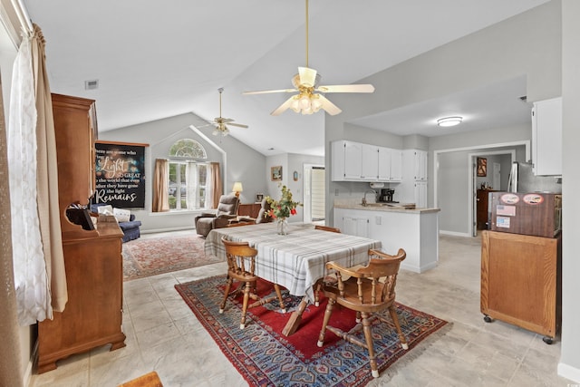 dining area featuring ceiling fan, sink, and lofted ceiling