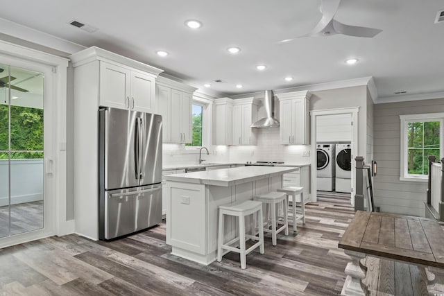 kitchen featuring washing machine and clothes dryer, a center island, appliances with stainless steel finishes, and white cabinets