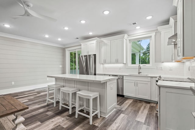 kitchen with stainless steel appliances, dark hardwood / wood-style flooring, sink, a center island, and white cabinets