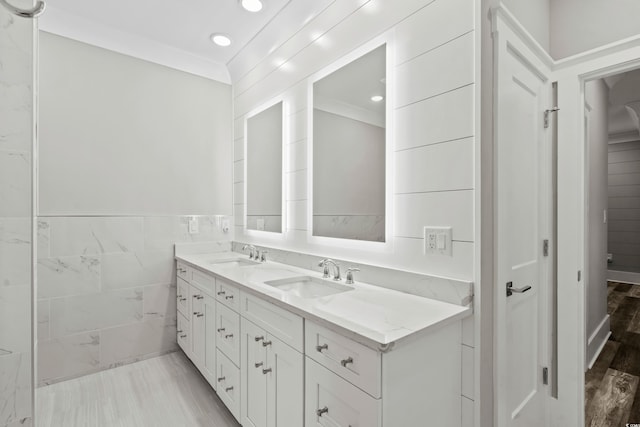 bathroom with hardwood / wood-style floors, ornamental molding, and vanity