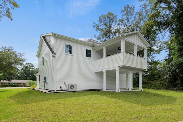 rear view of house featuring a yard, ac unit, and a balcony