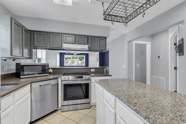 kitchen featuring a chandelier, white cabinetry, gray cabinetry, appliances with stainless steel finishes, and light tile patterned floors