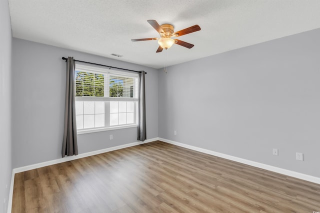 empty room with light hardwood / wood-style flooring, ceiling fan, and a textured ceiling