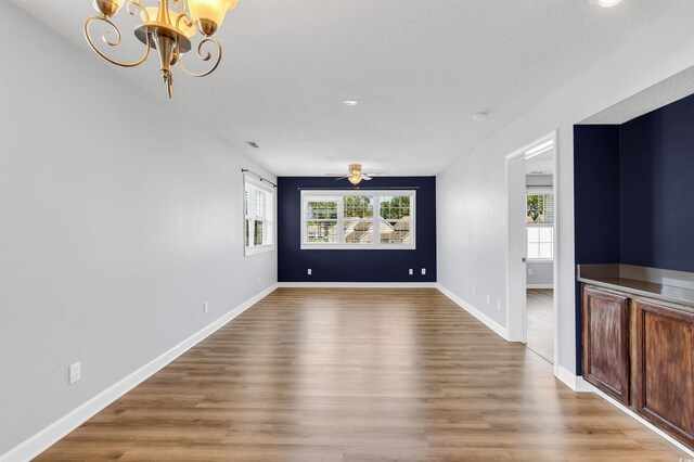 interior space featuring an inviting chandelier, a wealth of natural light, and wood-type flooring