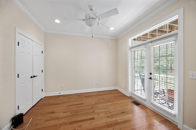 spare room featuring crown molding, plenty of natural light, light hardwood / wood-style flooring, and ceiling fan