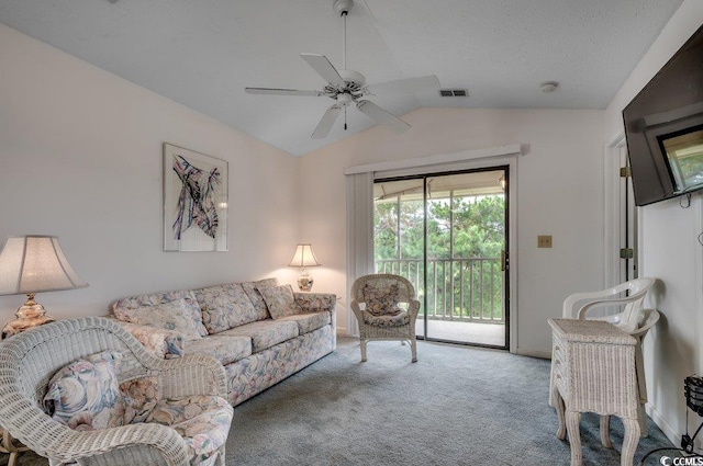 carpeted living room with ceiling fan and vaulted ceiling