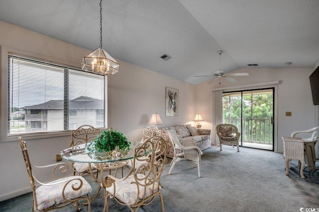 dining room featuring ceiling fan with notable chandelier, vaulted ceiling, and carpet floors