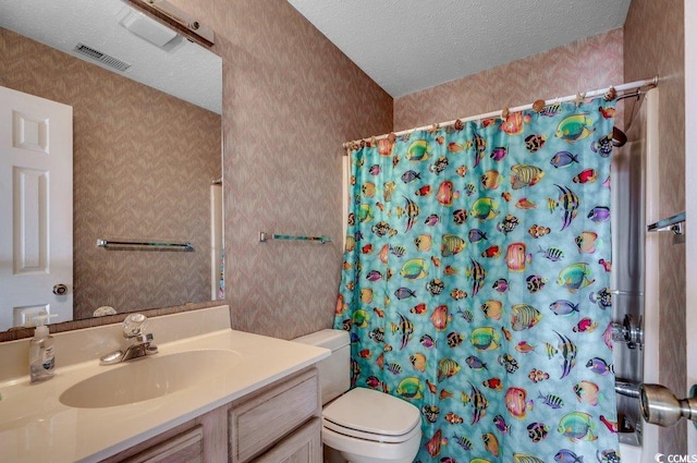 bathroom with walk in shower, vanity, toilet, and a textured ceiling