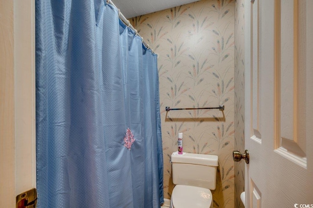 bathroom featuring toilet and a shower with curtain