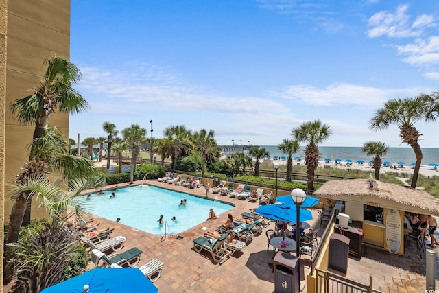 view of swimming pool with a water view and a patio