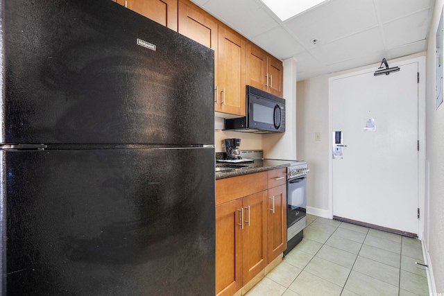 kitchen featuring black appliances, light tile patterned floors, and a paneled ceiling