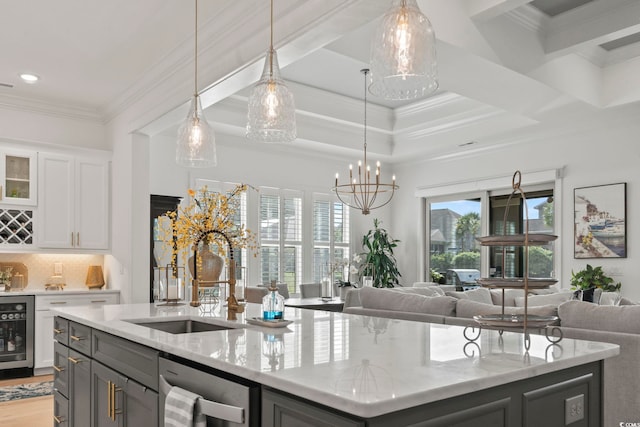 kitchen with dishwasher, a center island with sink, crown molding, light stone countertops, and white cabinetry