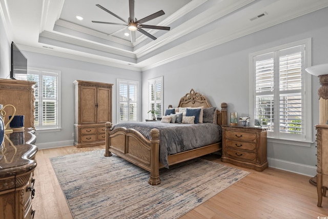 bedroom featuring light hardwood / wood-style flooring, ceiling fan, ornamental molding, and multiple windows