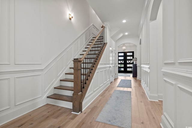 staircase featuring crown molding, french doors, and wood-type flooring