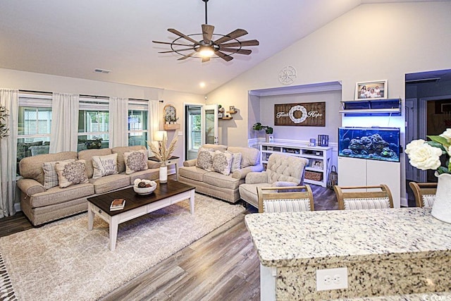 living area featuring ceiling fan, visible vents, vaulted ceiling, and wood finished floors