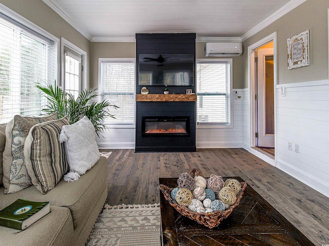 living room featuring wainscoting, a wall unit AC, dark wood-style floors, crown molding, and a fireplace