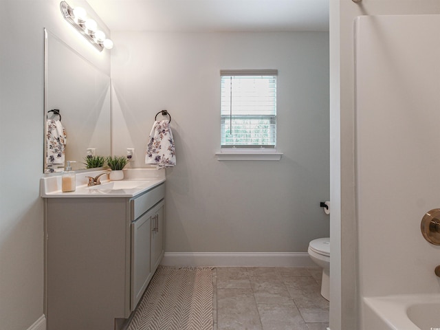 full bath featuring toilet, vanity, and baseboards