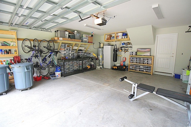 garage with a garage door opener, water heater, and a workshop area