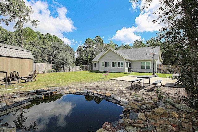 rear view of house featuring a patio area, a fenced backyard, and a lawn