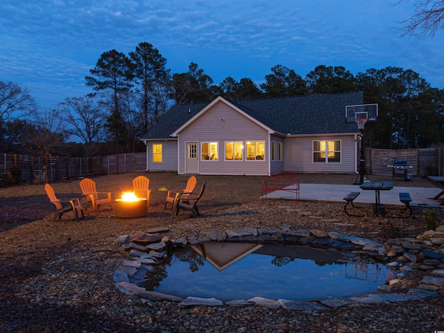 back of house featuring fence private yard, a patio area, a fire pit, and roof with shingles