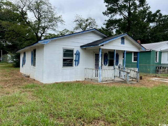 bungalow with a porch and a front lawn