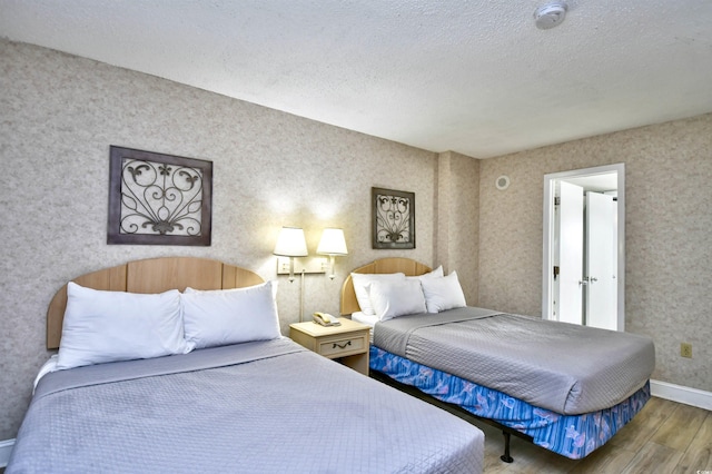 bedroom with a textured ceiling and hardwood / wood-style floors