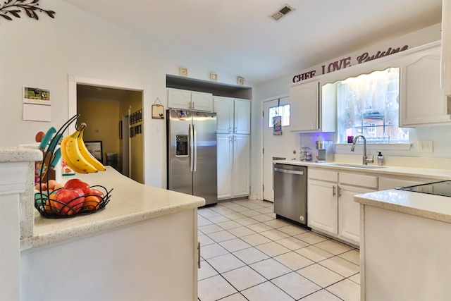 kitchen featuring appliances with stainless steel finishes, lofted ceiling, white cabinetry, and sink