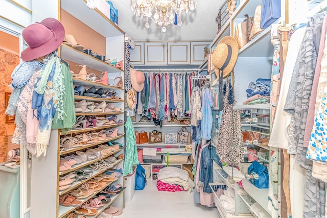 spacious closet with an inviting chandelier