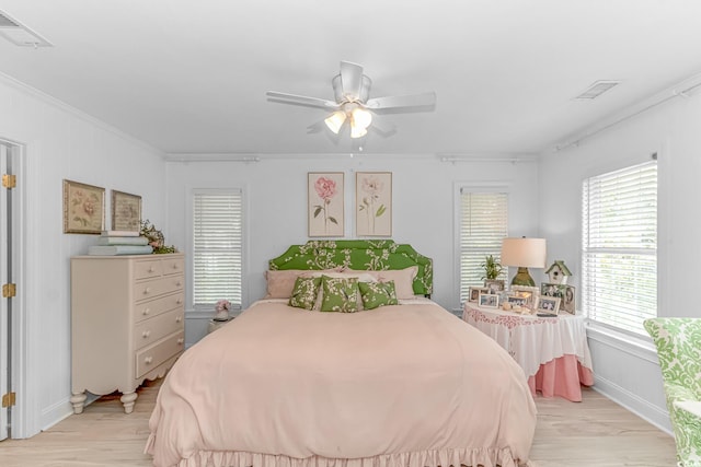 bedroom with ceiling fan, crown molding, and light hardwood / wood-style flooring