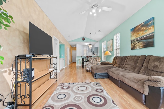 living area with visible vents, ceiling fan, light wood-style floors, and lofted ceiling