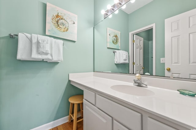 bathroom featuring vanity, baseboards, and wood finished floors