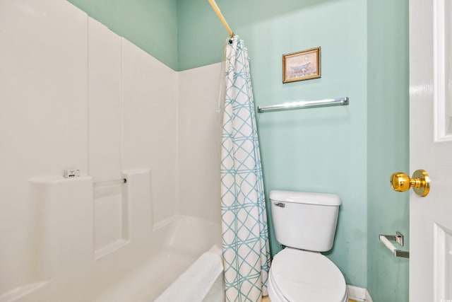 bathroom featuring curtained shower and toilet