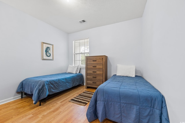 bedroom with visible vents, baseboards, and light wood-style floors