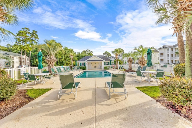 pool featuring fence and a patio area